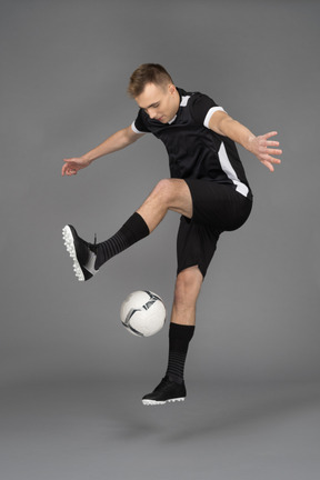 A young sporty man juggling a ball