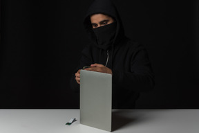 Hacker guy enlever ordinateur portable dans l'obscurité