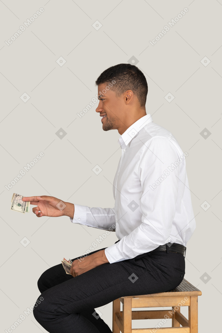 Lächelnder mann, der geld anbietet