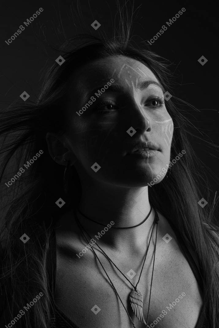 Retrato noir da cabeça aos ombros de uma jovem esperançosa com arte no rosto olhando de lado