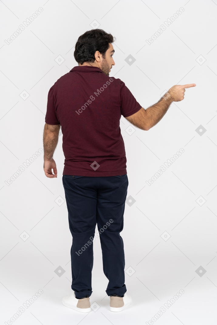 Vista posteriore di un uomo in abbigliamento casual che punta