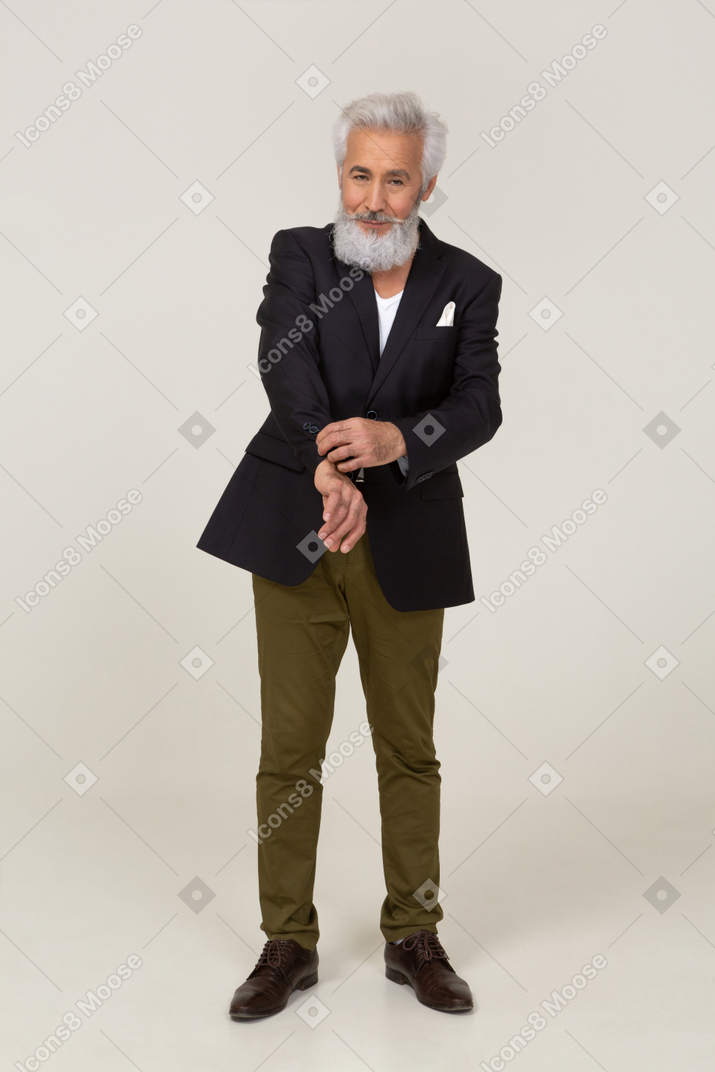 Cheerful man in a jacket fixing his cuff