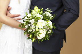 Sposa e sposo in possesso di un bouquet da sposa