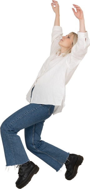 一名金发碧眼的女性，穿着休闲服tip着脚跳舞，举起手的侧视图