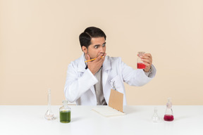 Worried young male caucasian scientist looking at bulb