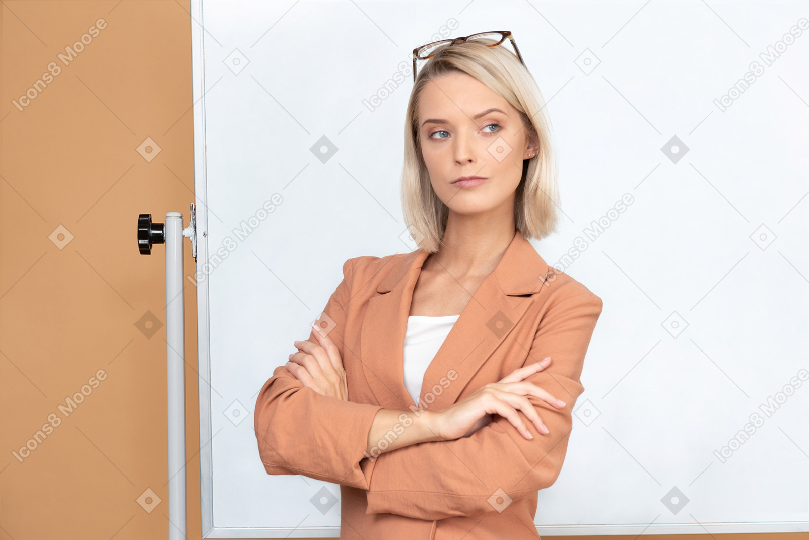 Beautiful young teacher in terracotta jacket standing with her hands crossed