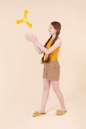 Teenage girl playing with boomerang