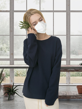 A woman wearing a face mask and holding a plant