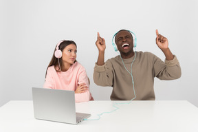 Atractiva pareja escuchando música en auriculares.