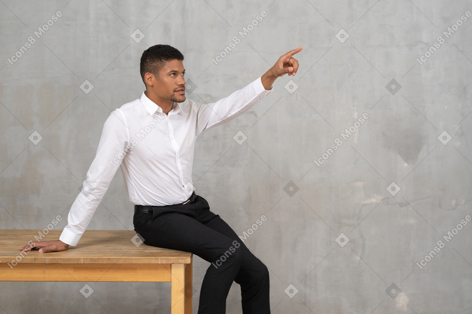Mann sitzt auf einem tisch und zeigt nach oben