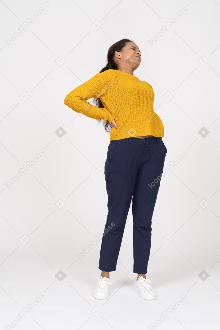 Front view of a girl in casual clothes suffering from pain in lower back