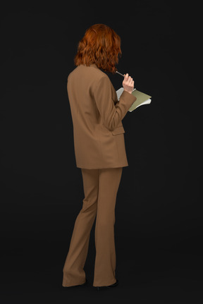 Holding notebook  woman in formal suit standing back to camera