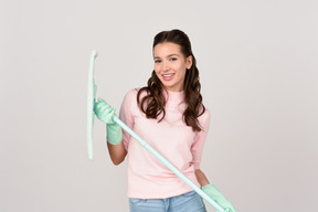 Attractive young woman holding a mop