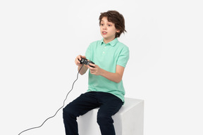 集中してビデオ ゲームをプレイする十代の少年