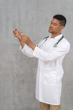 Male doctor preparing a syringe