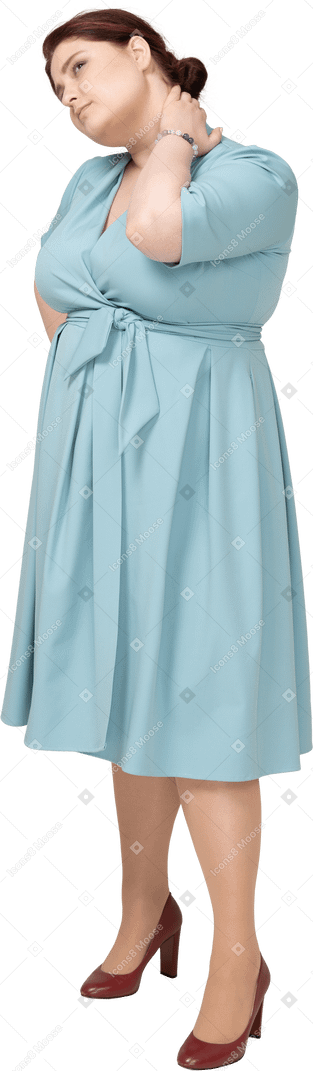 Vista frontal de una mujer en vestido azul que sufre de dolor en el cuello