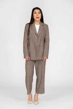 Front  view of a young lady in brown business suit licking her lips