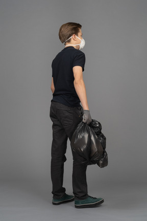 Un homme tenant un sac poubelle noir