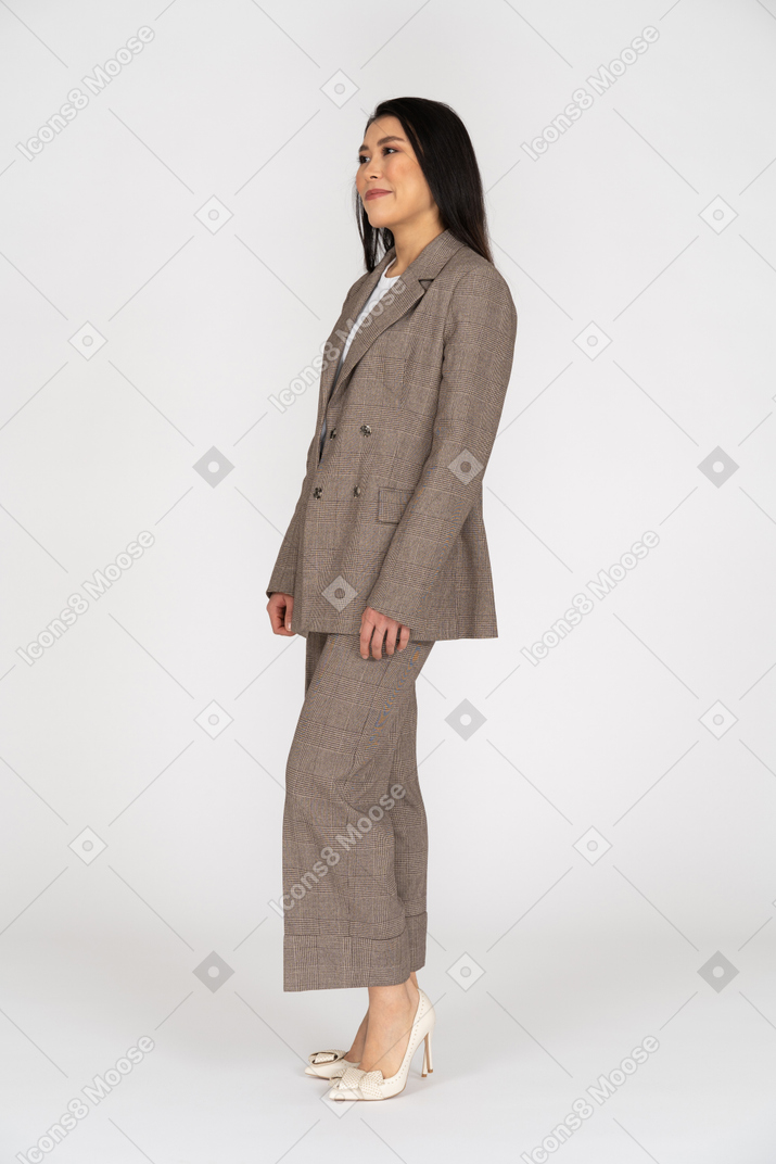 Three-quarter view of a smirking young lady in brown business suit