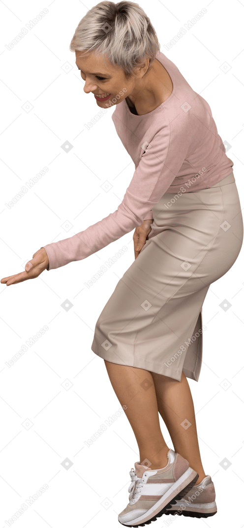 Vista lateral de uma mulher feliz em roupas casuais mostrando um gesto de boas-vindas
