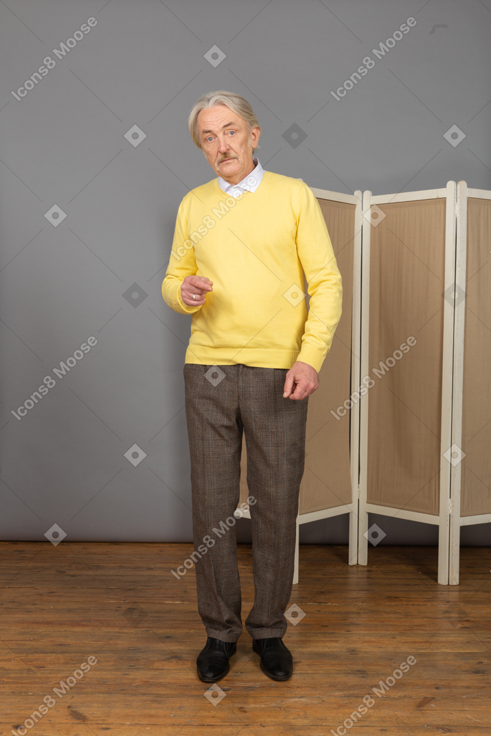 Vue de face d'un vieil homme gesticulant regardant la caméra