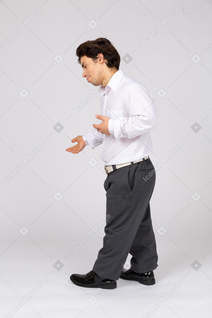Вид сбоку на мужчину в деловой повседневной одежде, жестикулирующего