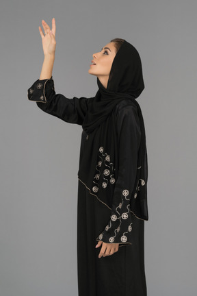 Muslim woman pointing upwards