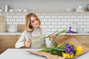 A woman holding a bouquet of flowers in a kitchen