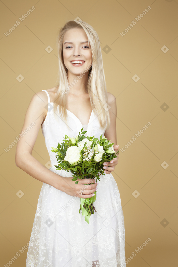 Beautiful bride holding bouquet and posing for a photo