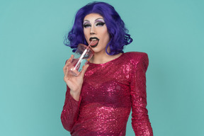 Portrait of a drag queen in pink sequin dress having a drink