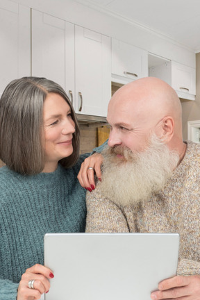 Um homem e uma mulher olhando para um laptop
