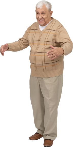 Vista frontal de um velho feliz em roupas casuais em pé com os braços estendidos