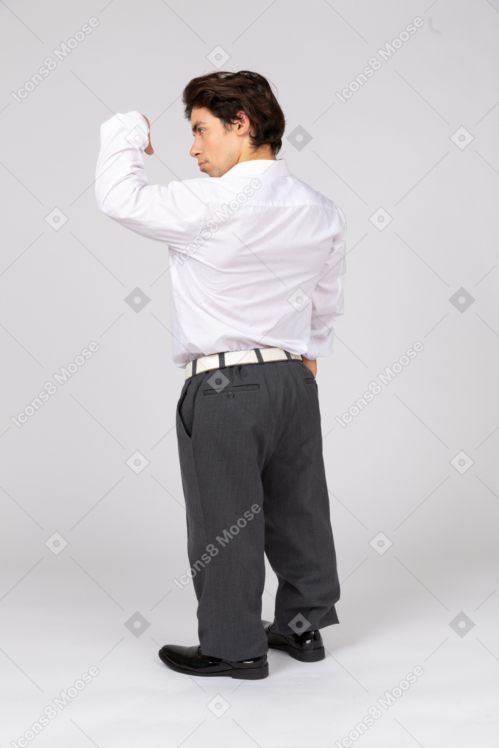 Back view of an office worker flexing arm muscles