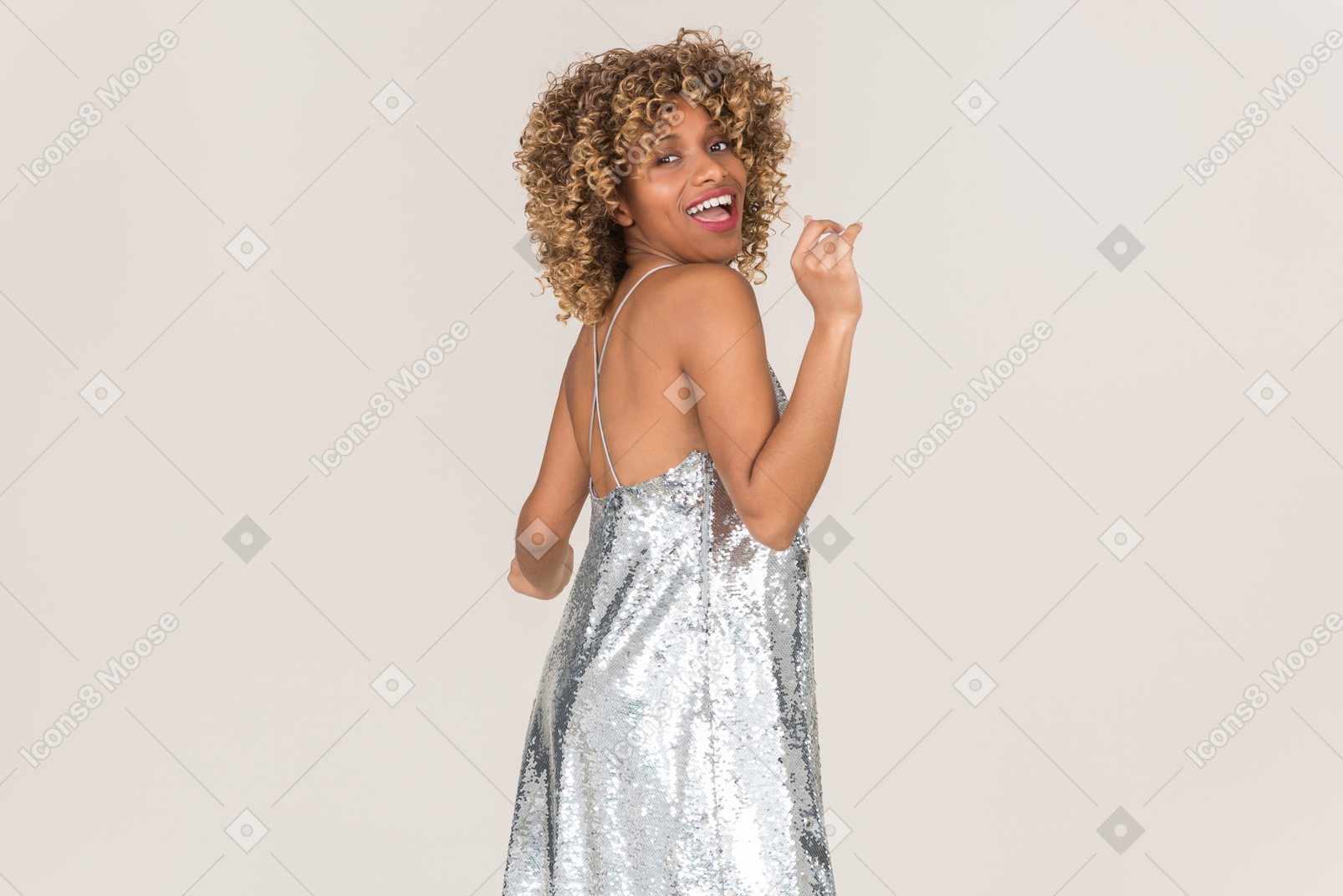 Mujer joven en vestido gris brillante bailando