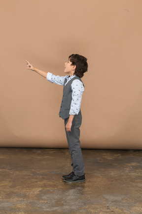 Side view of a boy in grey suit pointing