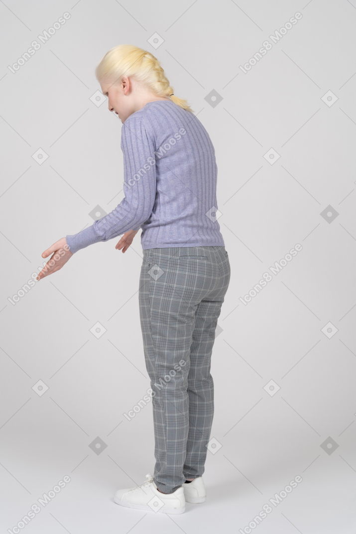 Vista posteriore di tre quarti di una donna protesa in avanti e gesticolante