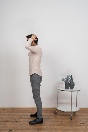 Seitenansicht eines mannes in freizeitkleidung, der mit den händen hinter dem kopf posiert