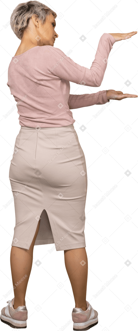 Vista trasera de una mujer en ropa casual que muestra el tamaño de algo