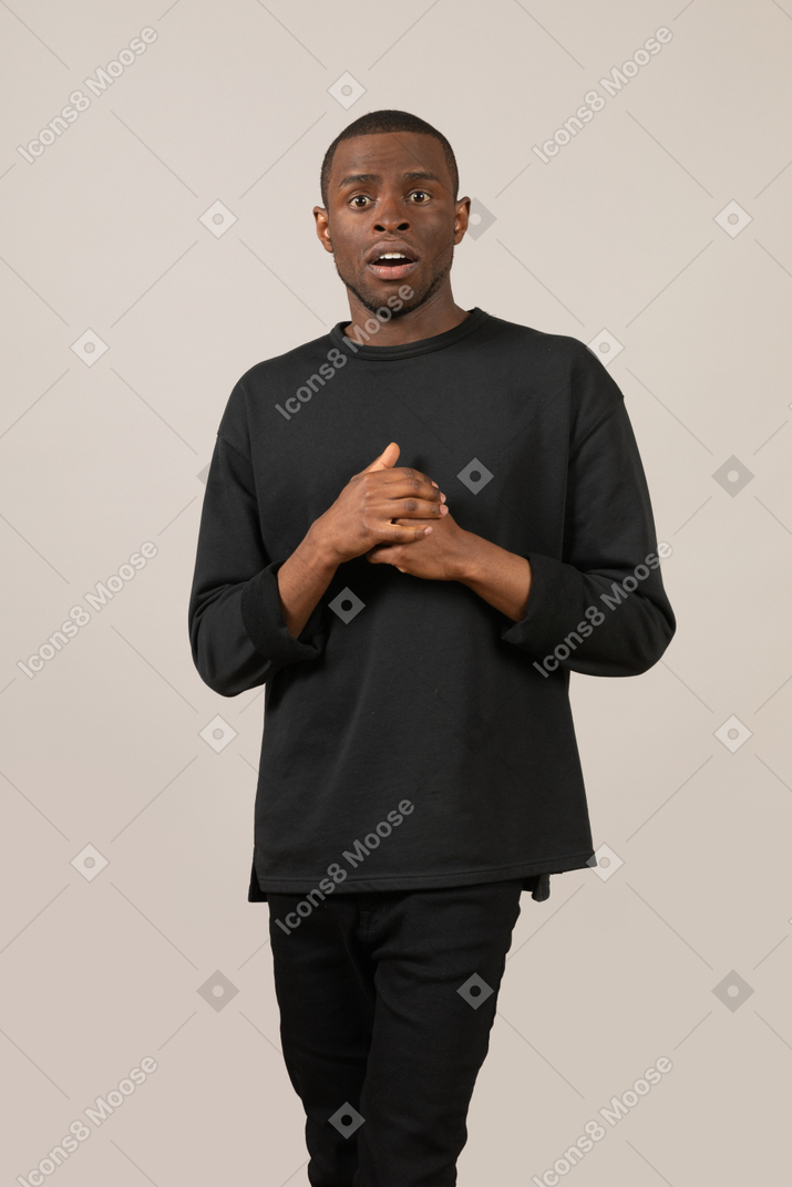 Scared young man with folded hands