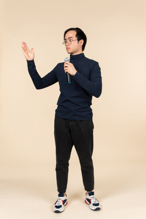 Young asian man speaking into a microphone