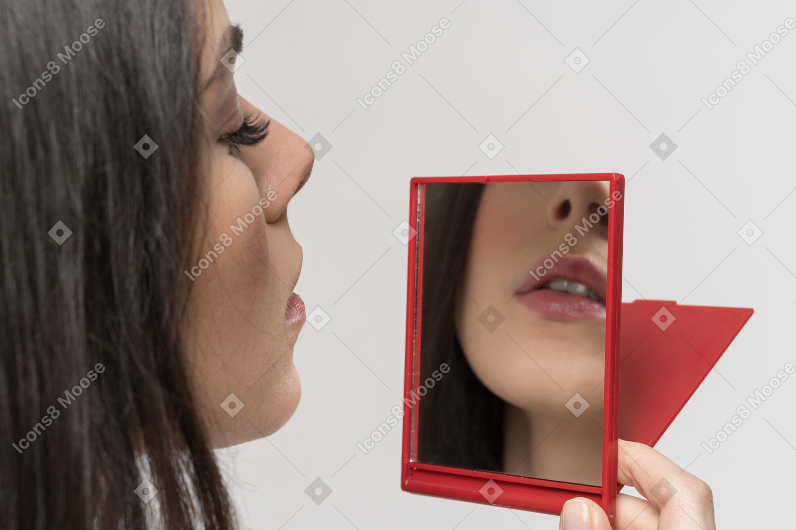 Bonita mujer mirando el espejo de mano rojo