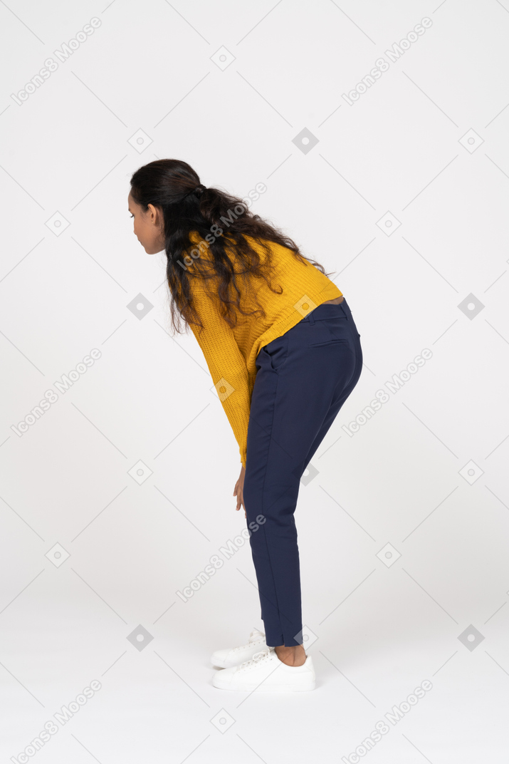 Vista lateral de uma garota com roupas casuais se abaixando