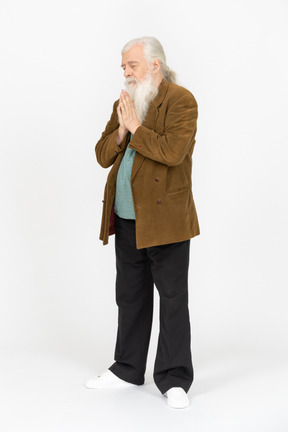 Elderly man with hands folded in prayer