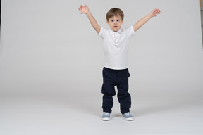 Front view of a boy standing with hands up