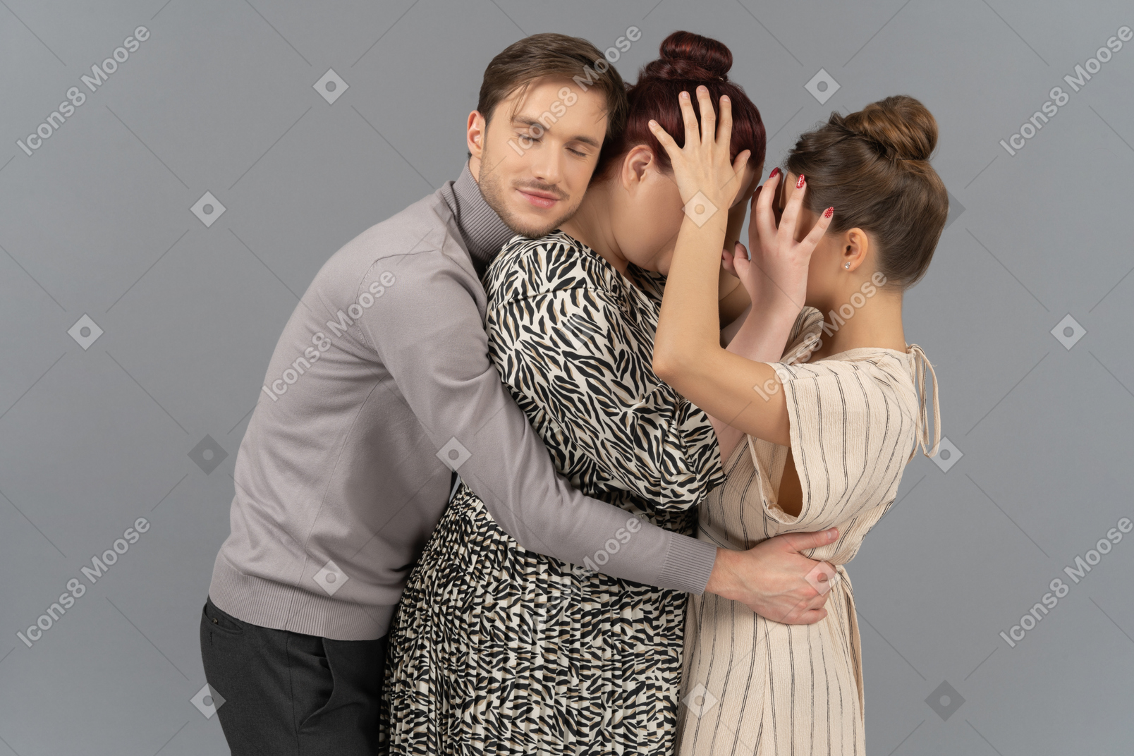 Young man embracing two young rival women