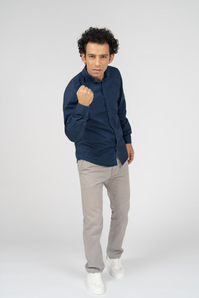 Vista frontal de um homem com roupas casuais mostrando o punho