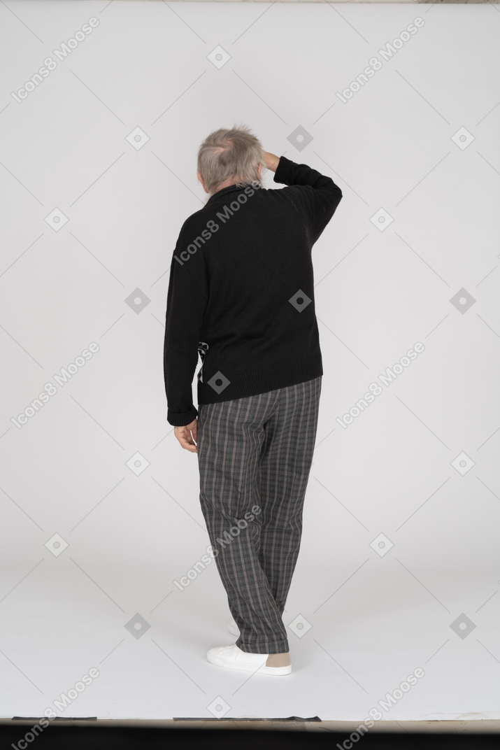 Rear view of old man with hand on forehead