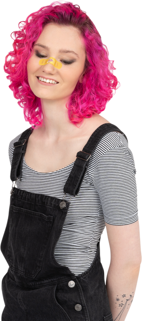 Pink-haired girl with yellow plaster looks down smiling