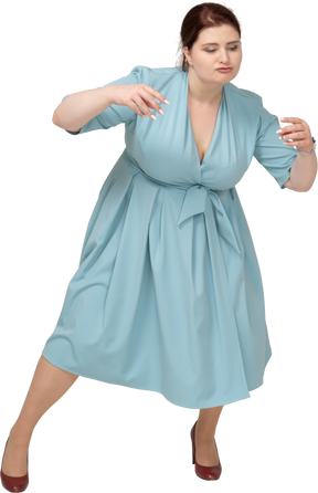 Vista frontal de uma mulher de vestido azul dançando
