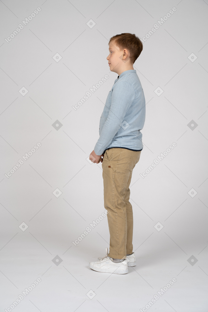 Shy boy standing in profile